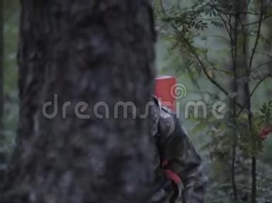 身穿<strong>迷彩</strong>制服背包的游客穿过森林。 猎人探索领土，环顾四周。